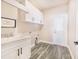 Laundry room with white cabinets, marble countertop, and vinyl flooring at 5017 Ridgefield Lane, Lakeland, FL 33812