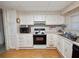 White kitchen cabinets, wood floors, and a corner sink at 619 Cassandra Ln, Lakeland, FL 33809