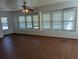 Living room boasts large windows, wood-look floors and ceiling fan at 1610 Reynolds Rd # 236, Lakeland, FL 33801