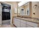 Bathroom with double vanity, granite countertop, and view of shower at 6529 Longwood Trace S Ln, Lakeland, FL 33811