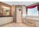 Bathroom with double vanity, soaking tub, and a walk-in shower at 6529 Longwood Trace S Ln, Lakeland, FL 33811