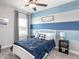 Spacious bedroom with a queen bed and stylish blue accent wall at 5478 Duxford Cir, Saint Cloud, FL 34771