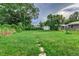 Large backyard with grassy area, shed, and mature trees at 2529 Weber St, Lakeland, FL 33801