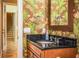 Guest bathroom with dark vanity and tropical-themed wallpaper at 4848 Island Shores Ln, Lakeland, FL 33809