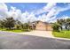 Two-story house with a three-car garage, palm trees and manicured lawn at 4848 Island Shores Ln, Lakeland, FL 33809