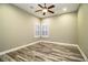 Bright bedroom with wood-look floors, ceiling fan and window with shutters at 4848 Island Shores Ln, Lakeland, FL 33809