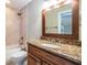 Bathroom with granite countertop, wood vanity, and shower/tub combo at 4848 Island Shores Ln, Lakeland, FL 33809