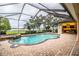 Enclosed pool area with lake view, outdoor kitchen, and brick pavers at 4848 Island Shores Ln, Lakeland, FL 33809