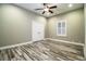 Spacious bedroom with wood-look floors, ceiling fan, and window with shutters at 4848 Island Shores Ln, Lakeland, FL 33809