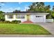 Charming ranch home with a green door, white exterior, and manicured lawn at 537 S Clayton Ave, Lakeland, FL 33801