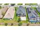 Aerial view showcasing the home's backyard, pool, and neighboring houses with solar panels at 6857 Eagle Ridge Loop, Lakeland, FL 33813