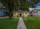 Yellow house with a walkway, tree, and green lawn at dusk at 714 Winfree Ave, Lakeland, FL 33801