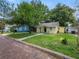 Yellow house on a brick street with a tree and a neighboring blue house at 714 Winfree Ave, Lakeland, FL 33801