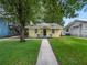 Yellow house with walkway, tree, and well-maintained green lawn at 714 Winfree Ave, Lakeland, FL 33801