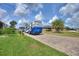 Brick paved driveway with a large RV parked, tall palm trees, and lush lawn at 544 Narrow Pond Rd, Polk City, FL 33868