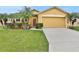 Tan house with two-car garage, palm trees, and well-maintained lawn at 834 Auburn Preserve Blvd, Auburndale, FL 33823