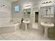 Main bathroom with double pedestal sinks, a large soaking tub, and a walk-in closet at 180 Lakeview Dr, Haines City, FL 33844