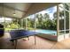 Screened patio with ping pong table, pool, and a view of the backyard at 310 Willow Oak Ct, Fort Meade, FL 33841