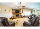 Spacious living room featuring a brick fireplace,reclining leather furniture, and a ceiling fan at 310 Willow Oak Ct, Fort Meade, FL 33841