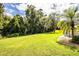 Lush green backyard with mature trees and lush landscaping at 310 Willow Oak Ct, Fort Meade, FL 33841