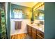 Bathroom with wood cabinets, granite countertop, and a shower with a rainforest curtain at 310 Willow Oak Ct, Fort Meade, FL 33841