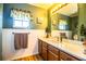 Bathroom with wood cabinets, granite countertop, and a window with a valance at 310 Willow Oak Ct, Fort Meade, FL 33841