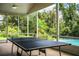 Outdoor table tennis in a screened porch with scenic view at 310 Willow Oak Ct, Fort Meade, FL 33841