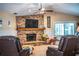 Living room with a brick fireplace, a large TV, and comfortable seating at 310 Willow Oak Ct, Fort Meade, FL 33841