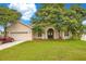 Tan house with a red car parked in the driveway at 2948 Vintage View Cir, Lakeland, FL 33812