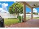 Brick patio, fenced backyard with lush green grass and a large tree at 2948 Vintage View Cir, Lakeland, FL 33812