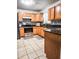 Well-lit kitchen with wood cabinets, granite counters, and tile floors at 2036 E Gachet Blvd, Lakeland, FL 33813