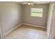 Simple bedroom featuring tile flooring and a window at 2584 Edmond Cir, Auburndale, FL 33823