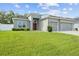 Gray house with two-car garage and lush green lawn at 8218 Wilder Loop, Lakeland, FL 33809