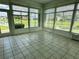 Bright sunroom with tile floors and multiple windows overlooking a pond at 1045 Caravan Loop, Polk City, FL 33868