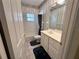 Bathroom with single sink vanity, tub, and window at 1045 Caravan Loop, Polk City, FL 33868