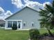 Rear view of house with sunroom and landscaping at 1045 Caravan Loop, Polk City, FL 33868