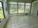 Bright sunroom with tile floors and multiple windows overlooking a pond at 1045 Caravan Loop, Polk City, FL 33868