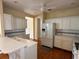 Kitchen with white cabinets, breakfast bar, and hardwood floors at 1045 Caravan Loop, Polk City, FL 33868