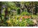 Tropical backyard with pond, lush foliage, and patio seating at 7525 Catherine Dr, Lakeland, FL 33810