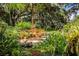 Serene backyard with pond, lush foliage, and patio seating at 7525 Catherine Dr, Lakeland, FL 33810