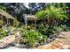 Landscaped backyard with pond, stone patio, and pergola at 7525 Catherine Dr, Lakeland, FL 33810