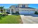 Two-story house with a three-car garage and lush lawn at 206 Clovis Pass, Winter Haven, FL 33880