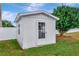 White storage shed with window and door, nestled in the backyard at 4618 Crestview Ln, Lakeland, FL 33813