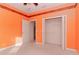 Bedroom with orange walls, carpet flooring, and walk-in closet at 5359 Nicklaus Dr, Winter Haven, FL 33884