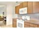 Kitchen features wood cabinets, white appliances, and a view to the living area at 6205 Raven Run, Lakeland, FL 33809