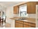 Kitchen features wood cabinets, double sink, and a window overlooking the backyard at 6205 Raven Run, Lakeland, FL 33809