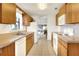 Bright kitchen with wood cabinets, white appliances, and a view to the dining area at 6205 Raven Run, Lakeland, FL 33809