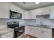 Modern kitchen with white cabinets, granite counters, and stainless steel appliances at 2350 E Washington St, Bartow, FL 33830