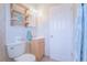 Updated bathroom with light wood vanity, new toilet, and floating shelves at 121 Coleman Rd, Winter Haven, FL 33880