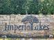 Imperial Lakes community entrance with a stone wall and metal tree art at 6128 Topher Trl # 6128, Mulberry, FL 33860